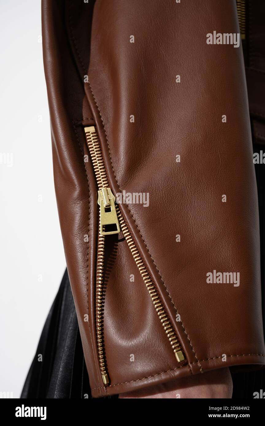 Brown leather jacket with metal zipper on the sleeve. Stitched leather. Closeup. Vertical photo. Stock Photo