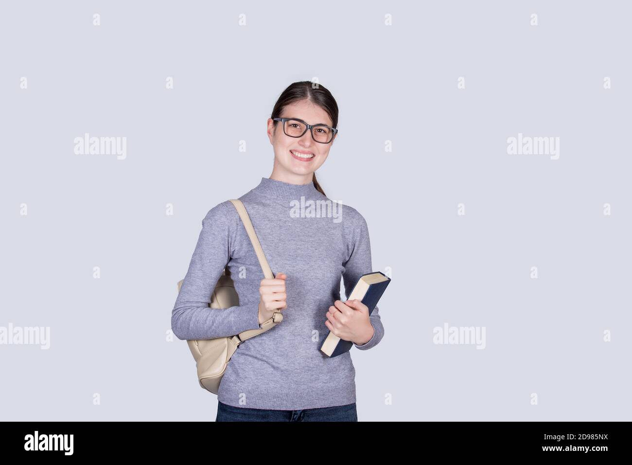 Confident student girl going to school holding one books and carrying ...
