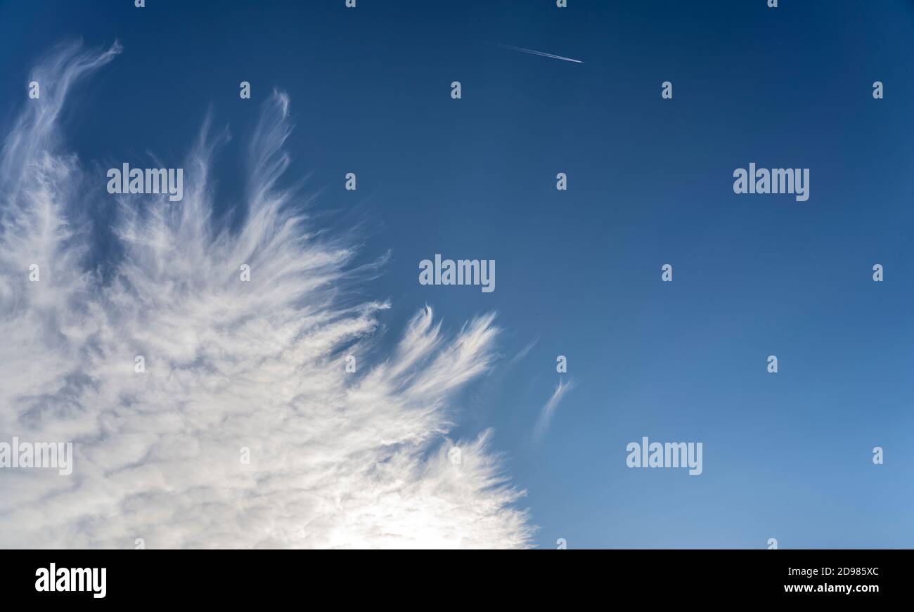 frayed cirrus clouds on deep blue sky Stock Photo