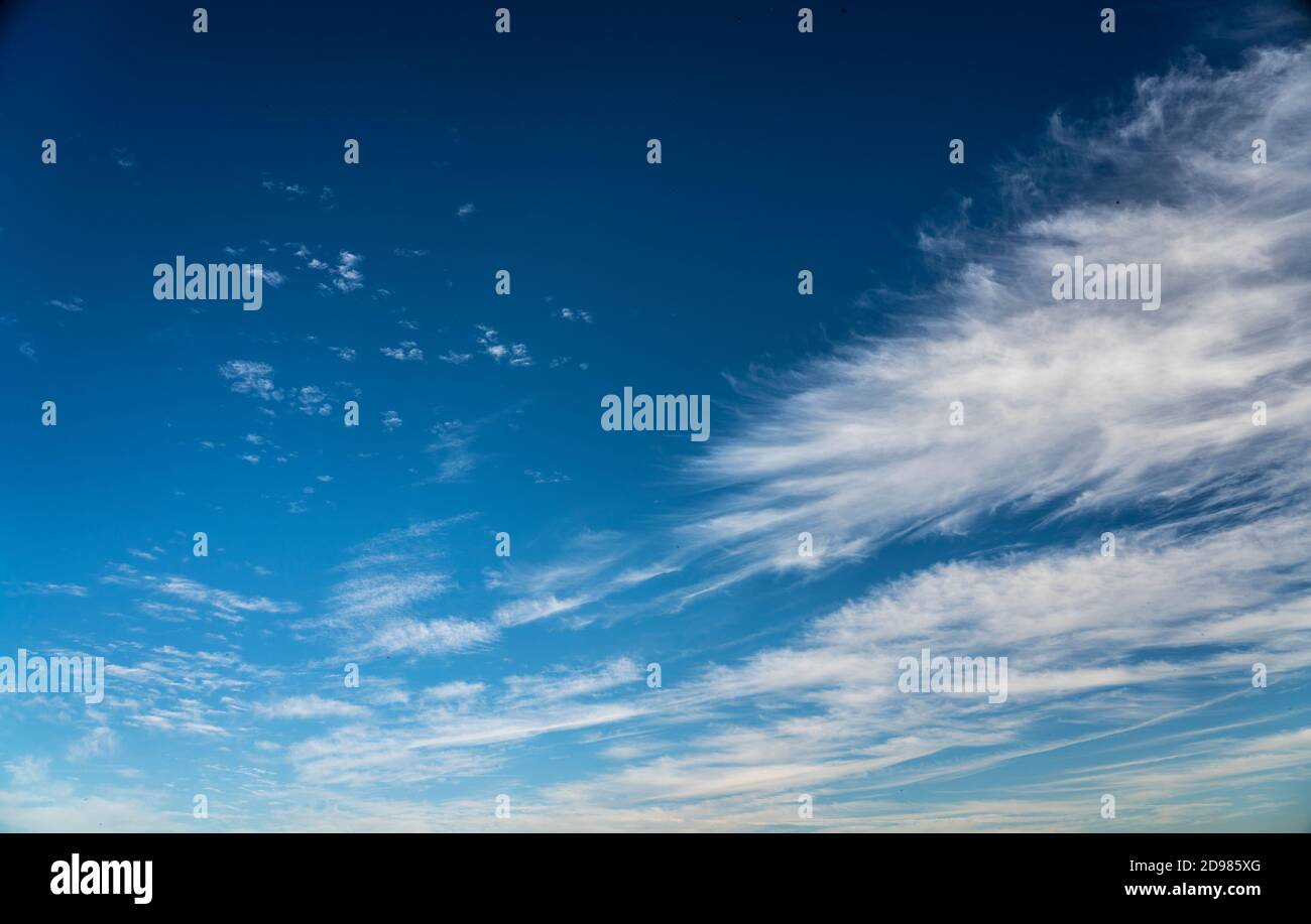 frayed cirrus clouds on deep blue sky Stock Photo
