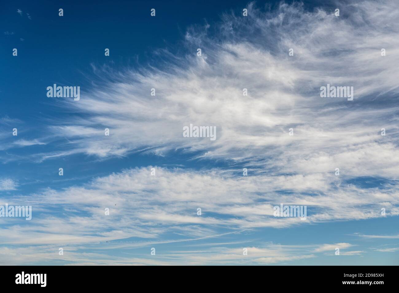 frayed cirrus clouds on deep blue sky Stock Photo