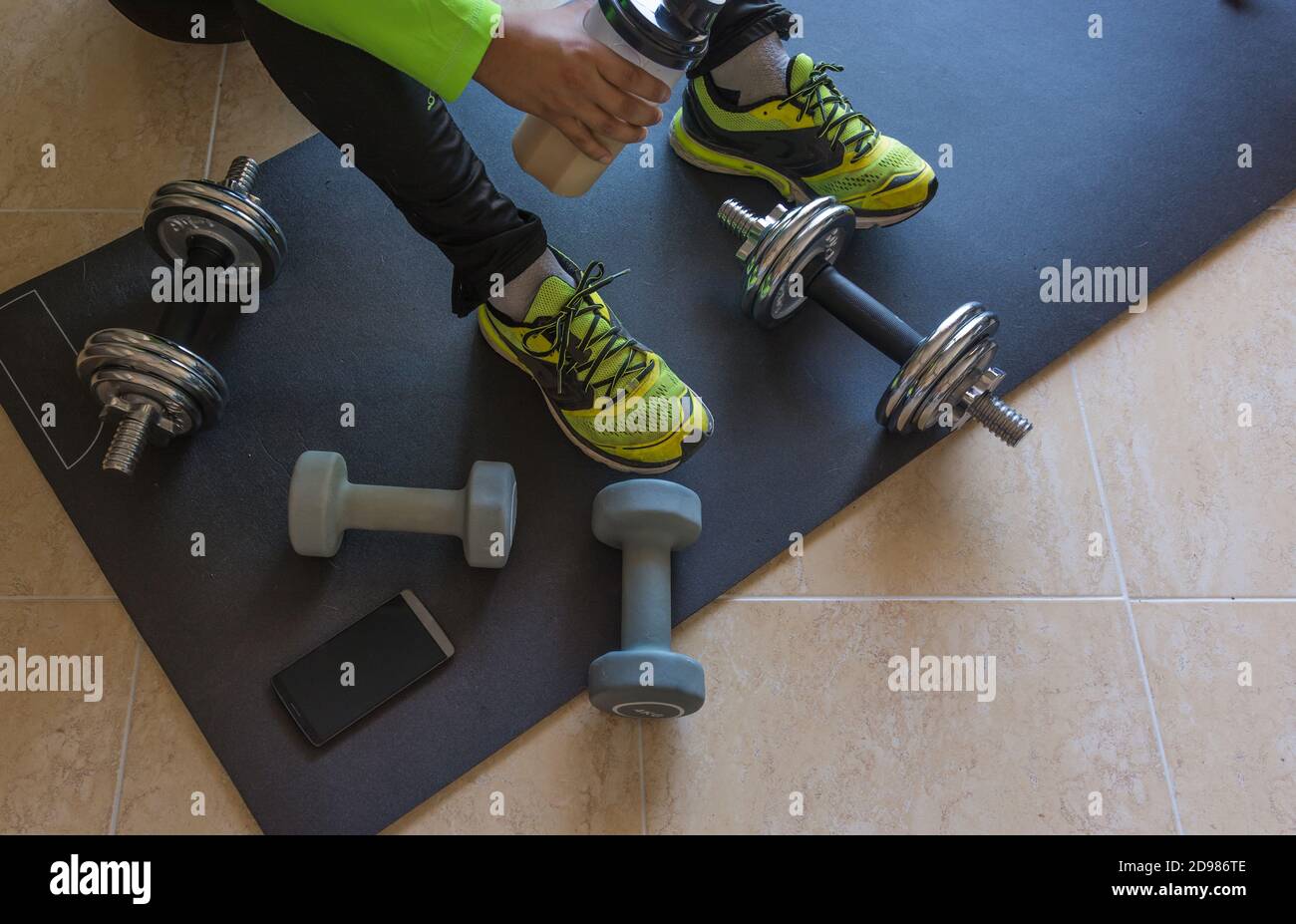 Dumbbell and mat training at home, and to drink a protein shake Stock ...