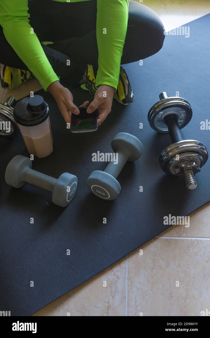 Dumbbell and mat training at home, and to drink a protein shake Stock ...