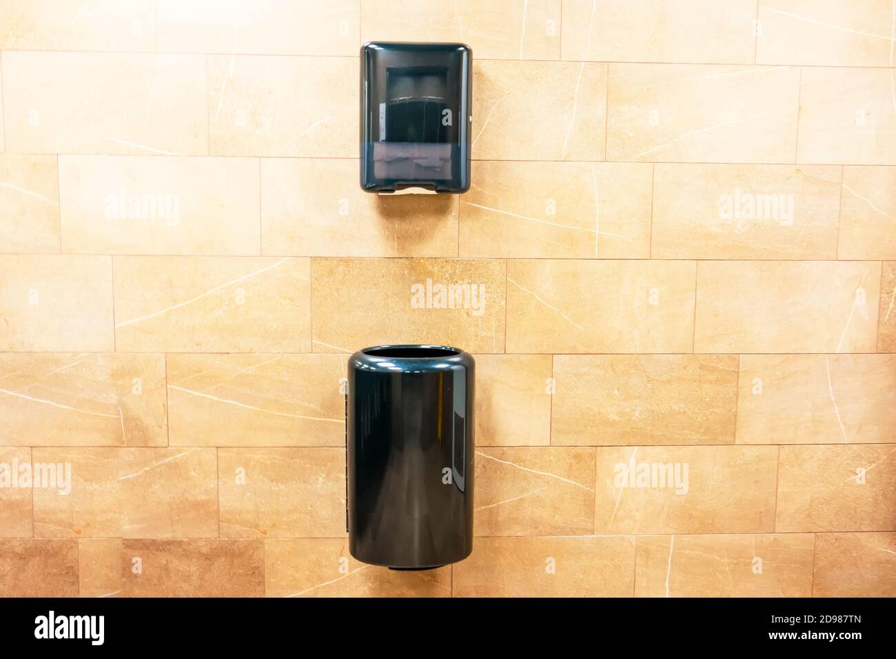 Paper towel black dispenser and a trash can at the bottom for used