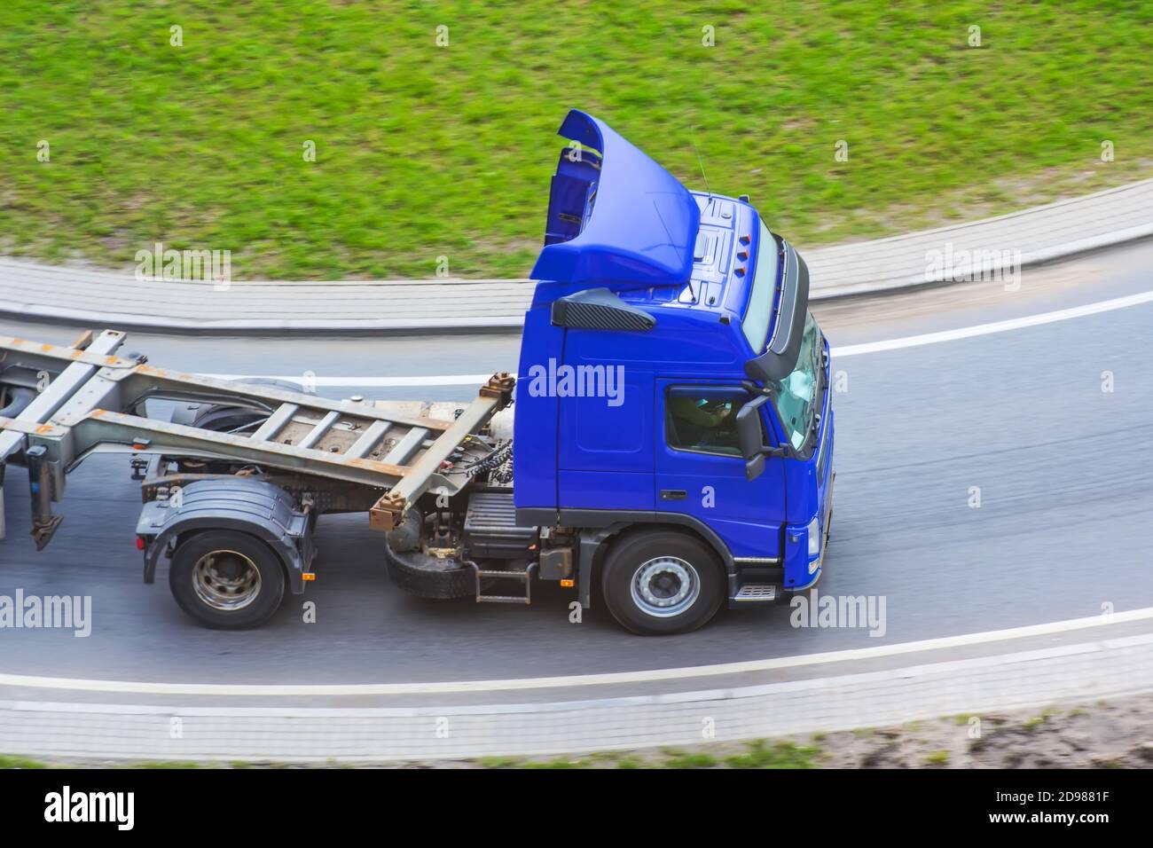 Truck with platform trailer on the bend Stock Photo