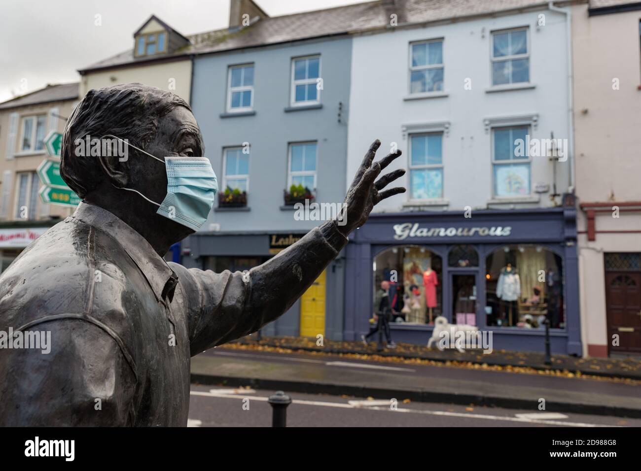 Listowel, Ireland - 24th October 2020:  Statue of the late writer and playwright  John B Keane with medical facemask in the town of Listowel during co Stock Photo