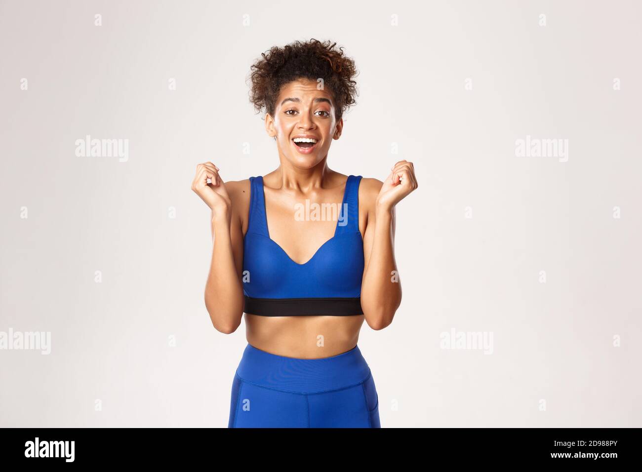 Concept of sport and workout. Excited and grateful african-american fitness woman winning, looking relieved, clenching fists delighted, achieve goal Stock Photo