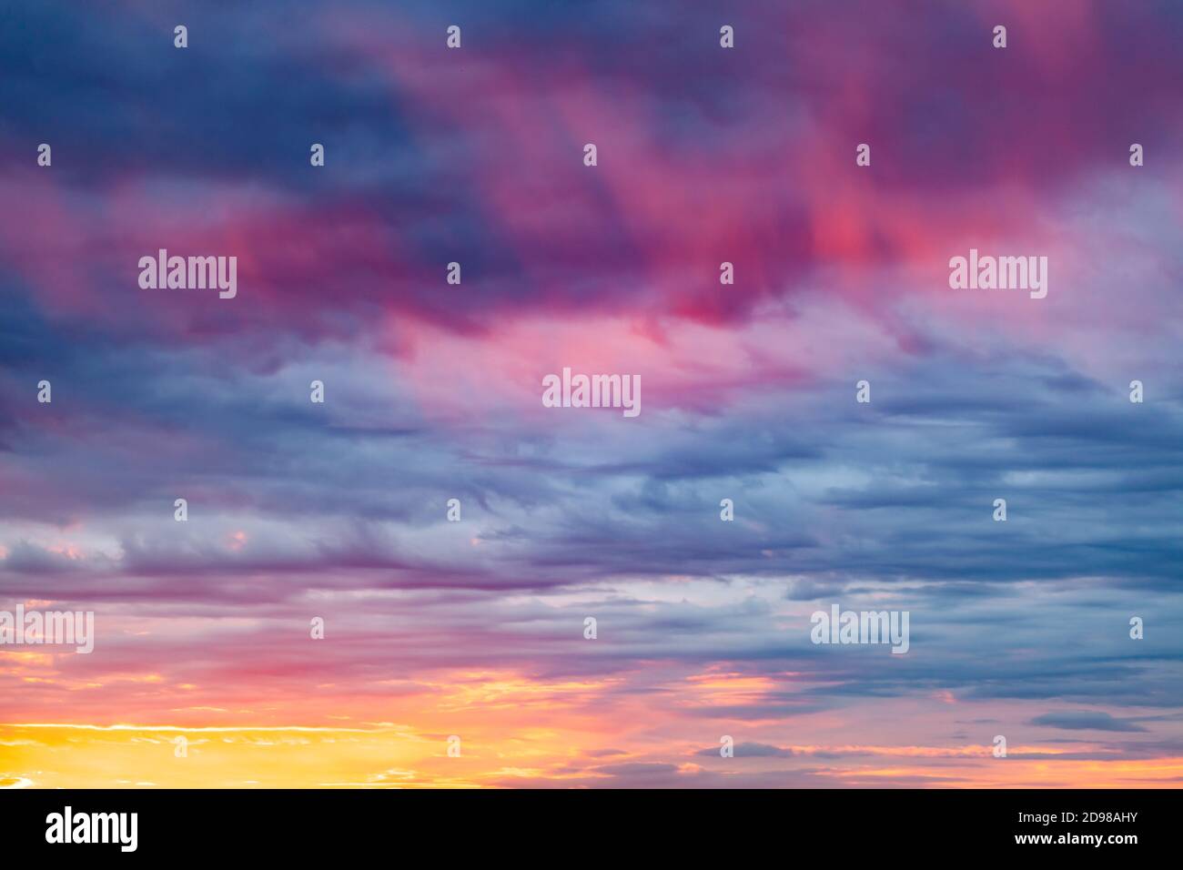 sunny sunset in cloudy blue sky with flame tongues Stock Photo