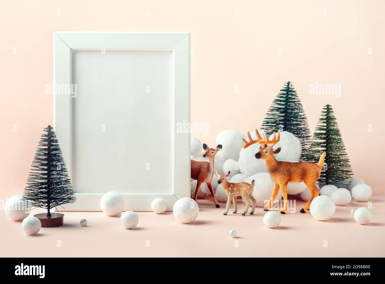 Christmas mockup frame with a decor of deer, fir trees and decorative snow Stock Photo