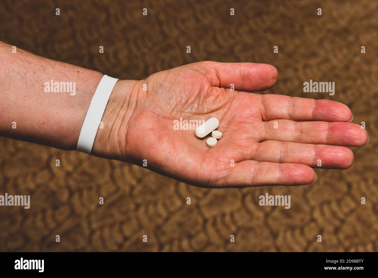 An elderly man holds his medicines and vitamins in his hands Stock Photo