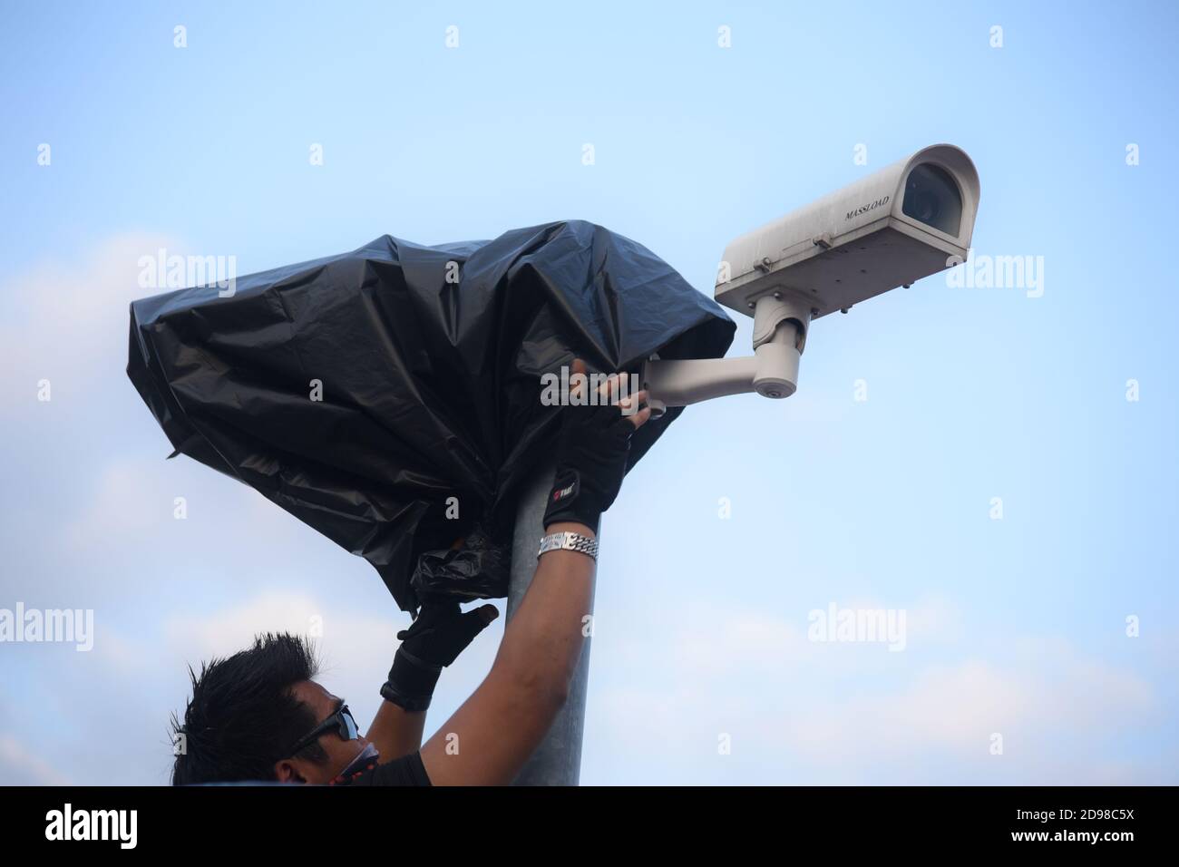 Bangkok, Thailand. 03rd Nov, 2020. A protester covers up a CCTV camera  during a demonstration following the blocking of the adult website Pornhub  outside the Ministry of Digital Economy and Society in