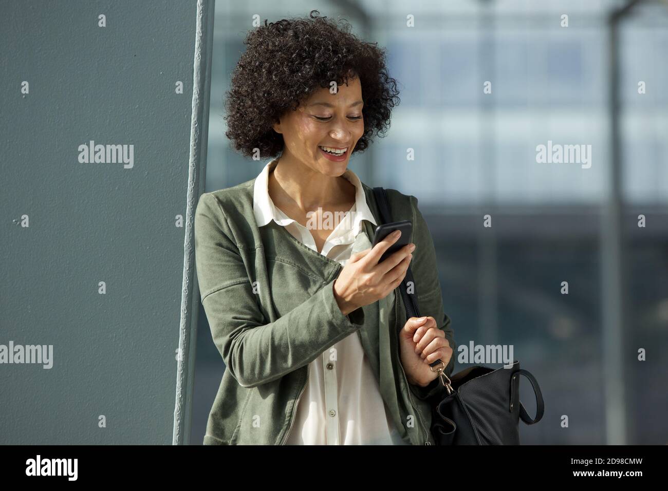 Portrait of smiling african american woman looking at cellphone Stock ...