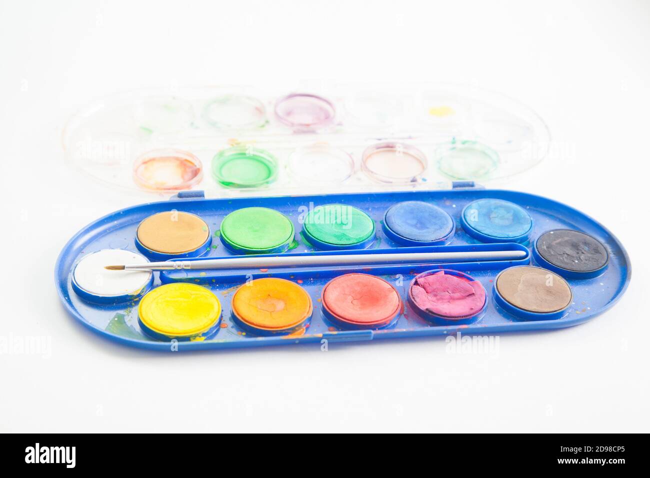 Side view of watercolor paint palette with brush inside on white