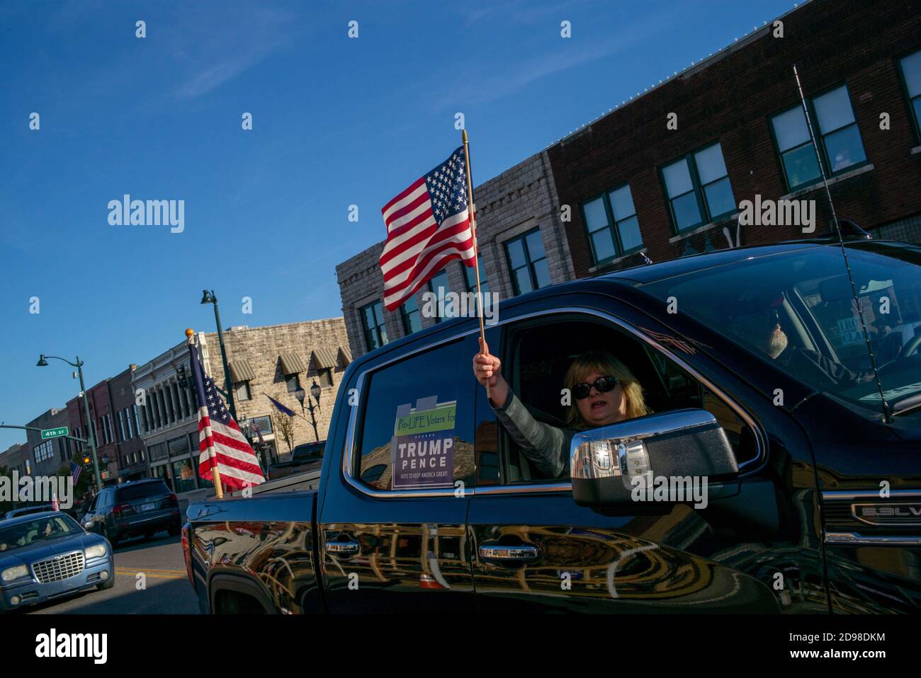 Manhattan, Kansas, USA. 1st Nov, 2020. Trump supporters wave to onlookers on Poyntz Avenue on Sunday during a Trump Parade. Heartland Trump Parades hosted a Trump Parade in Manhattan, Kansas on Sunday where around 165 cars and trucks showed up to show their support for President Donald Trump. The parade started in CiCo Park and drove through Historic downtown on Poyntz Avenue. Credit: Luke Townsend/ZUMA Wire/Alamy Live News Stock Photo
