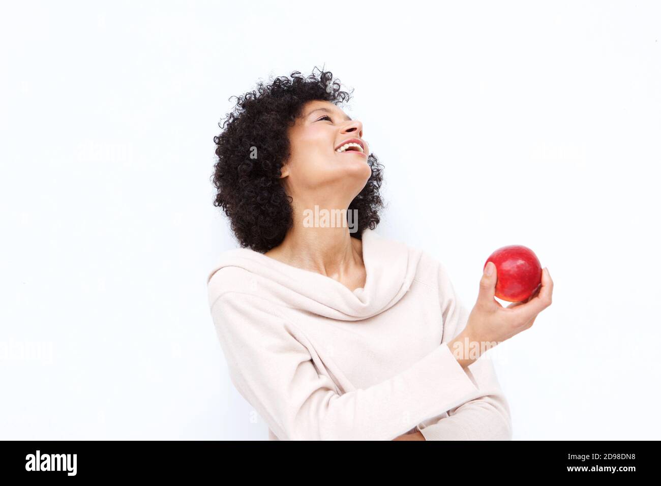 Portrait of happy woman holding apple against white background Stock Photo