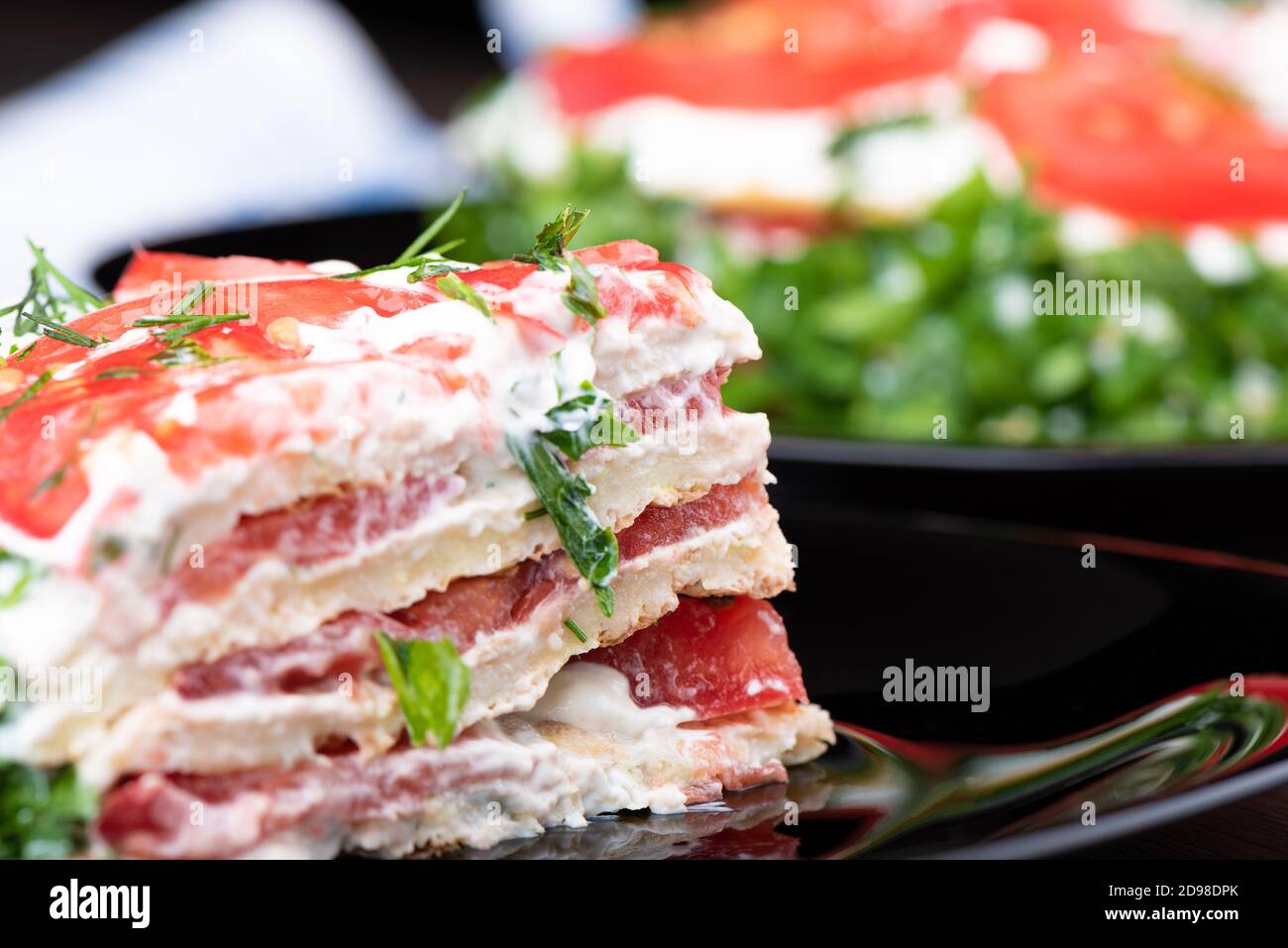 Close-up of a piece of zucchini puff pie on a black plate with reflection. Food background concept. Stock Photo