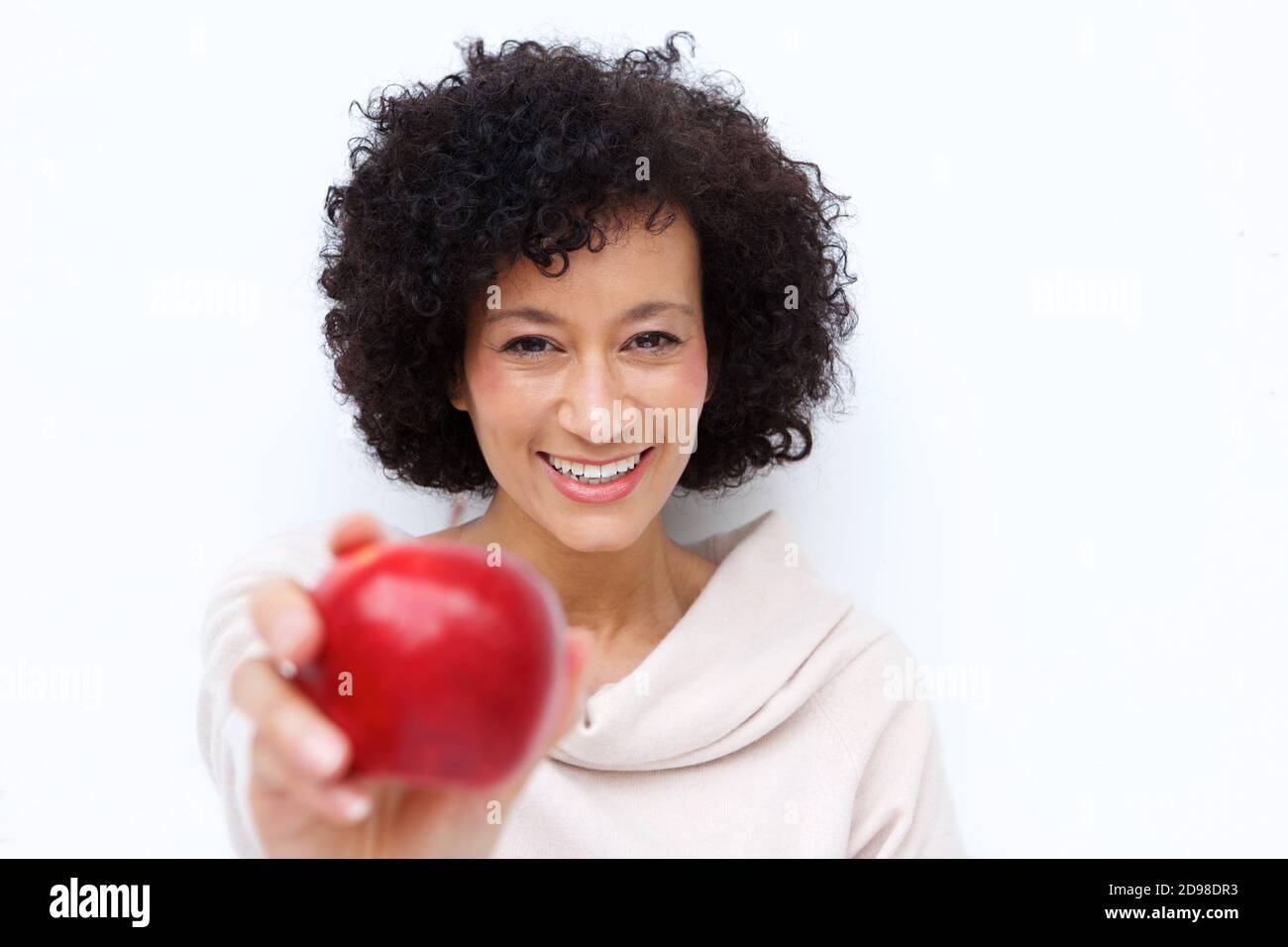 Close up portrait of smiling older woman holding red apple Stock Photo