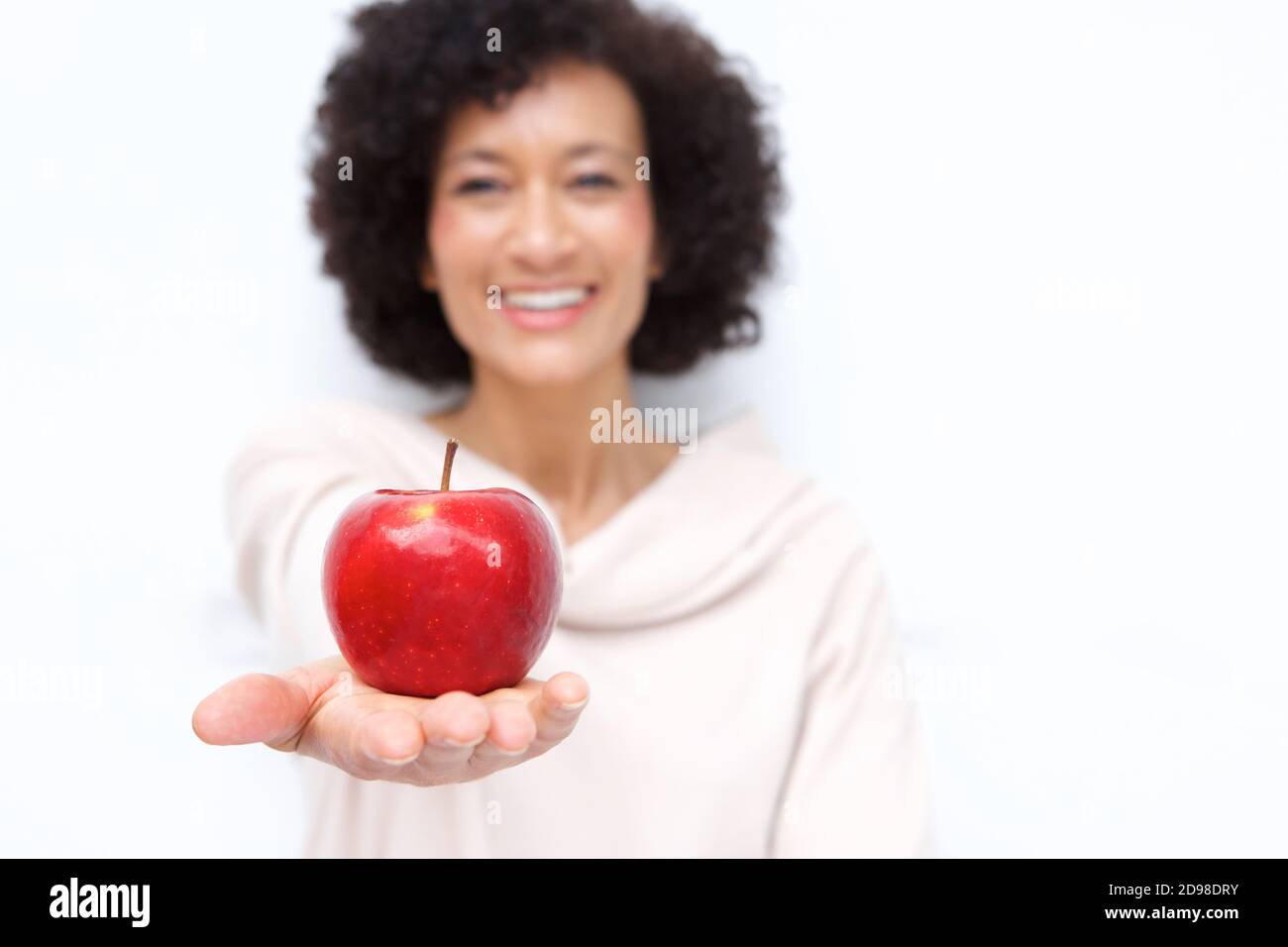 Close up portrait of older woman holding red apple in hand Stock Photo