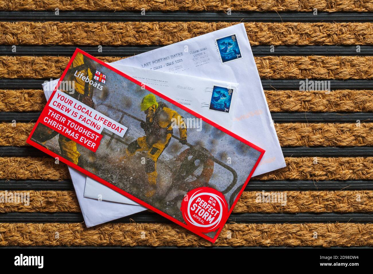 Post mail on doormat - charity appeal, RNLI Lifeboats perfect storm appeal your local lifeboat crew is facing their toughest Christmas ever Stock Photo