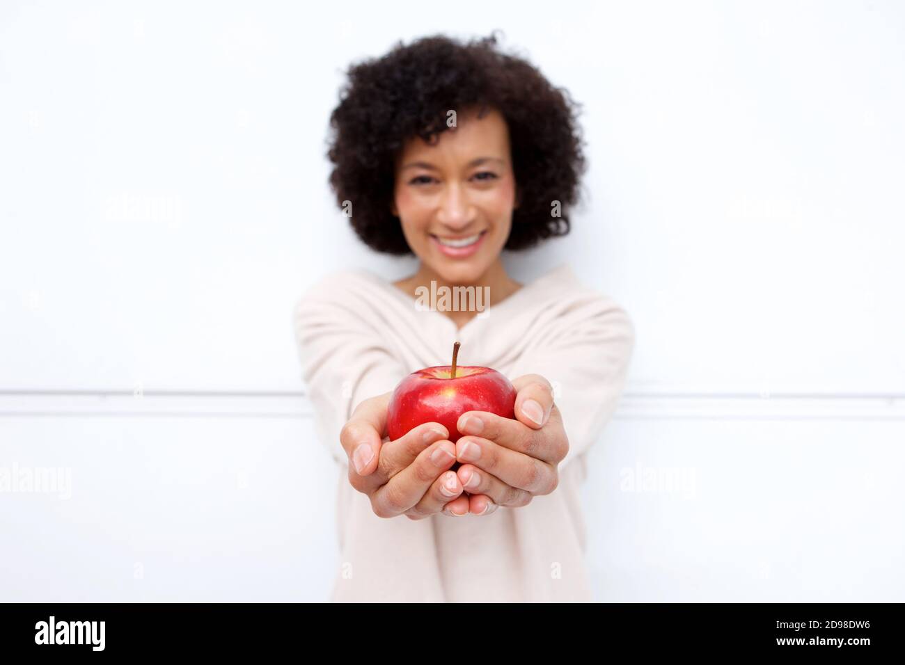 Portrait of happy healthy woman holding red apple in hands Stock Photo