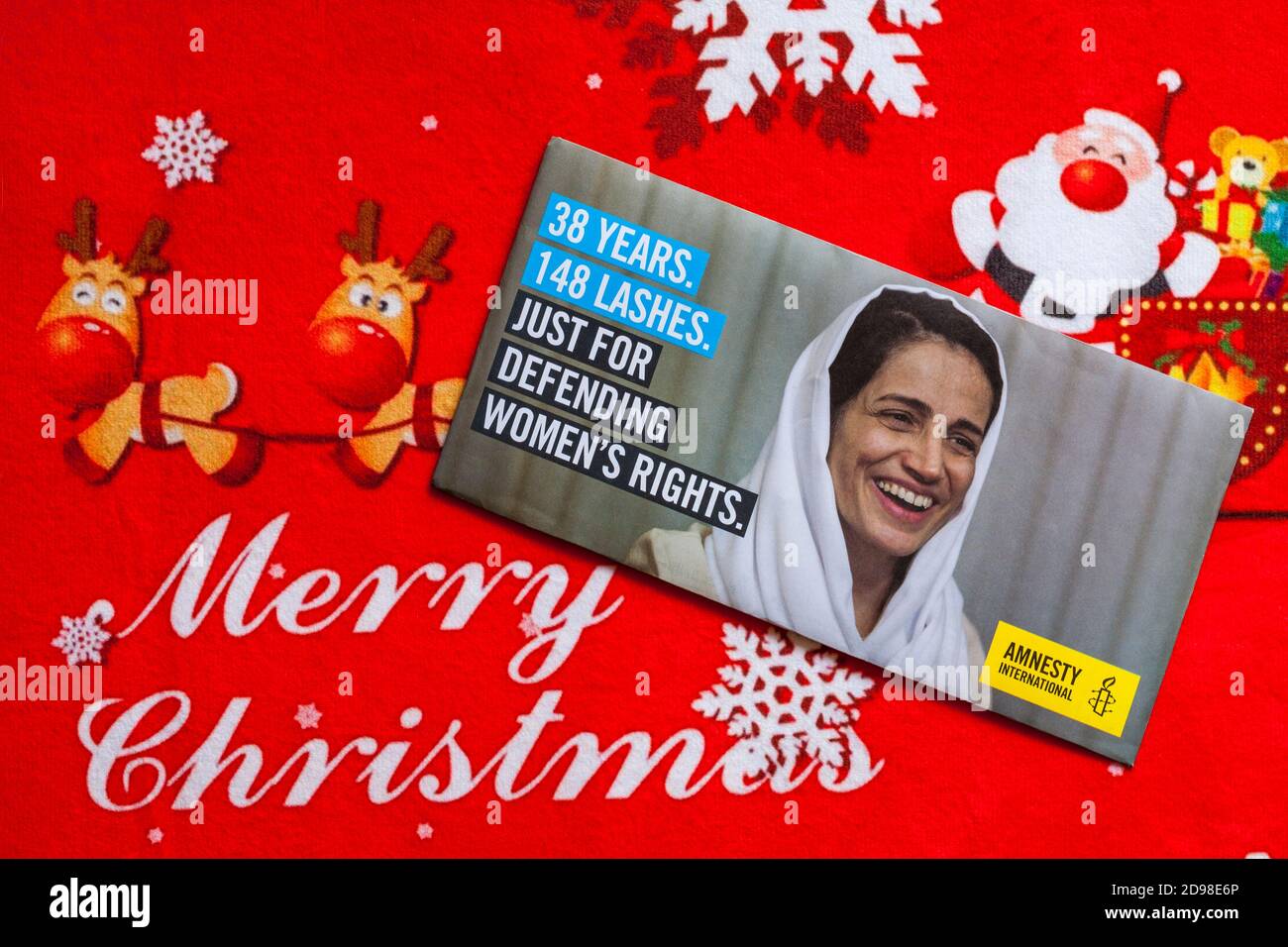 Post on Christmas mat - charity appeal, Amnesty International 38 years 148 lashes just for defending women's rights Stock Photo