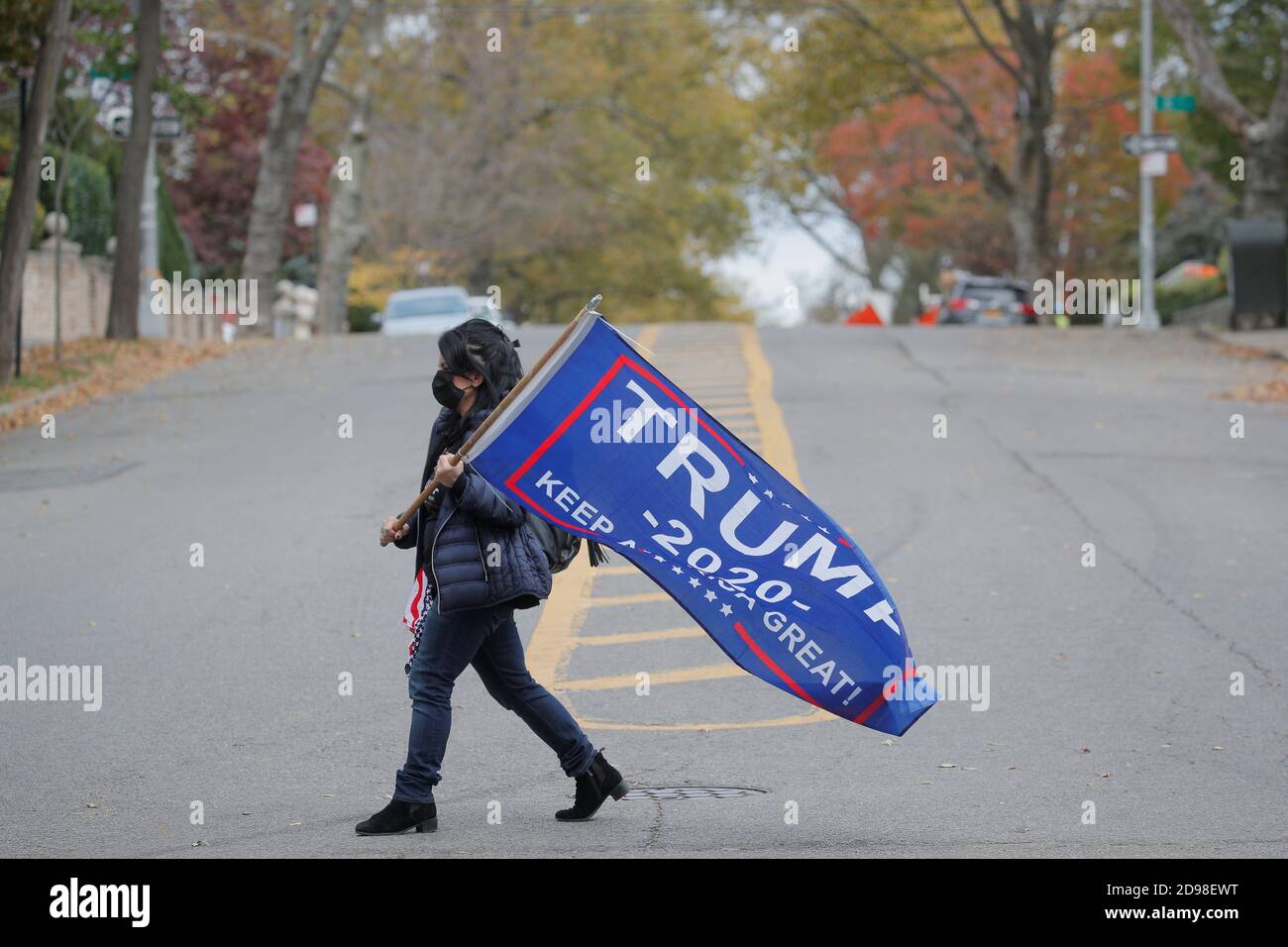 A woman carries a pro-Trump flag outside a polling site on election day in the Brooklyn borough of New York City, New York, U.S. November 3, 2020.  REUTERS/Brendan McDermid Stock Photo