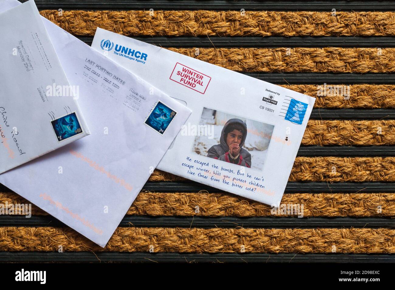 Post mail on doormat - charity appeal, UNHCR The UN Refugee Agency winter survival fund Stock Photo
