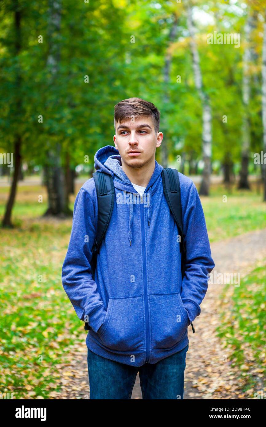 Pensive Young Man in the Autumn Forest Alone Stock Photo