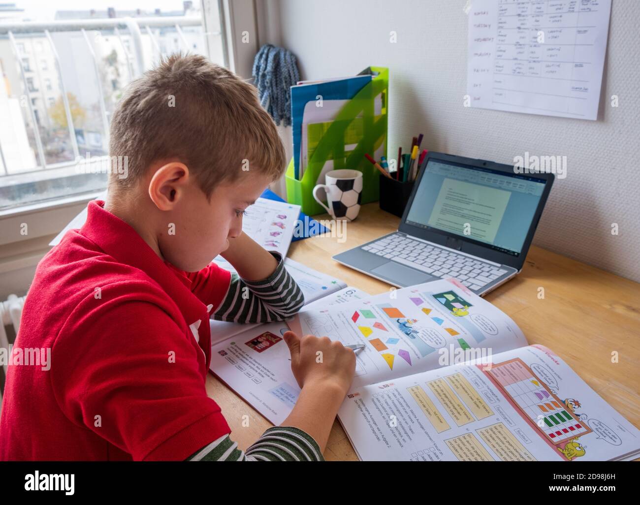 Boy concentrating during homeschooling in corona lockdown Stock Photo