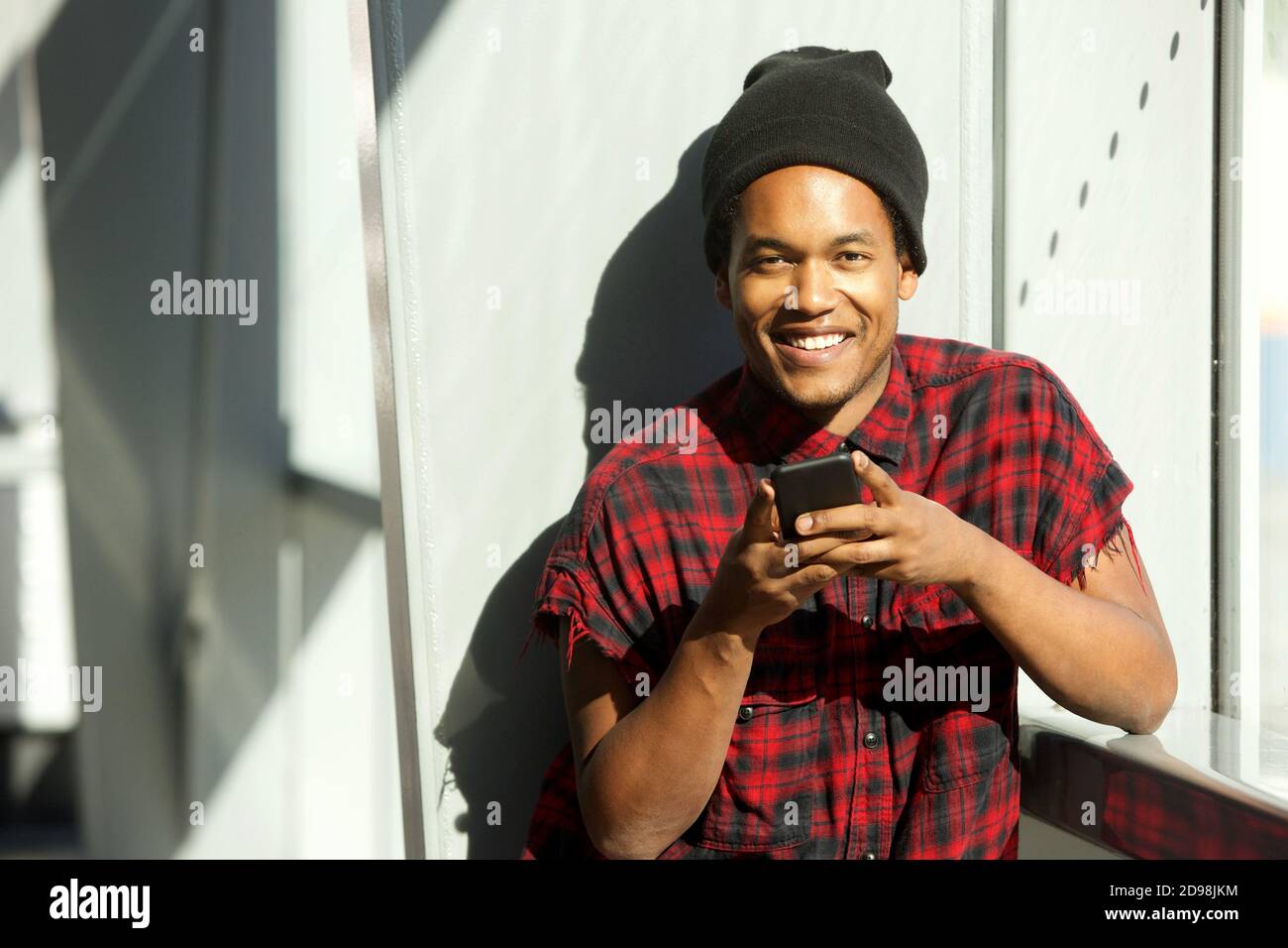 Portrait of cool young black man holding cellphone and smiling Stock ...