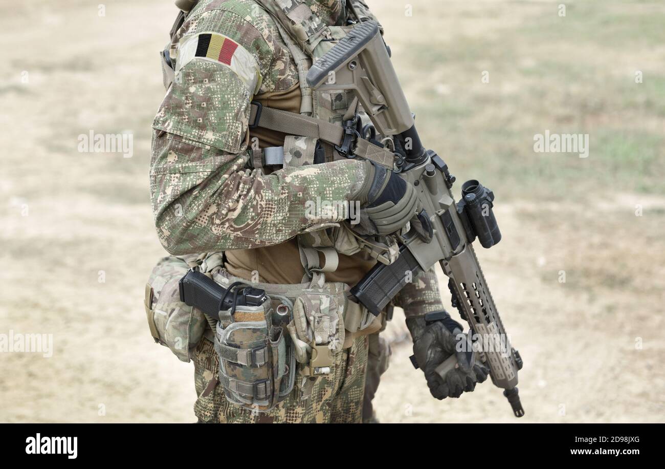 Soldier with assault rifle and flag of Belgium on military uniform. Collage. Stock Photo