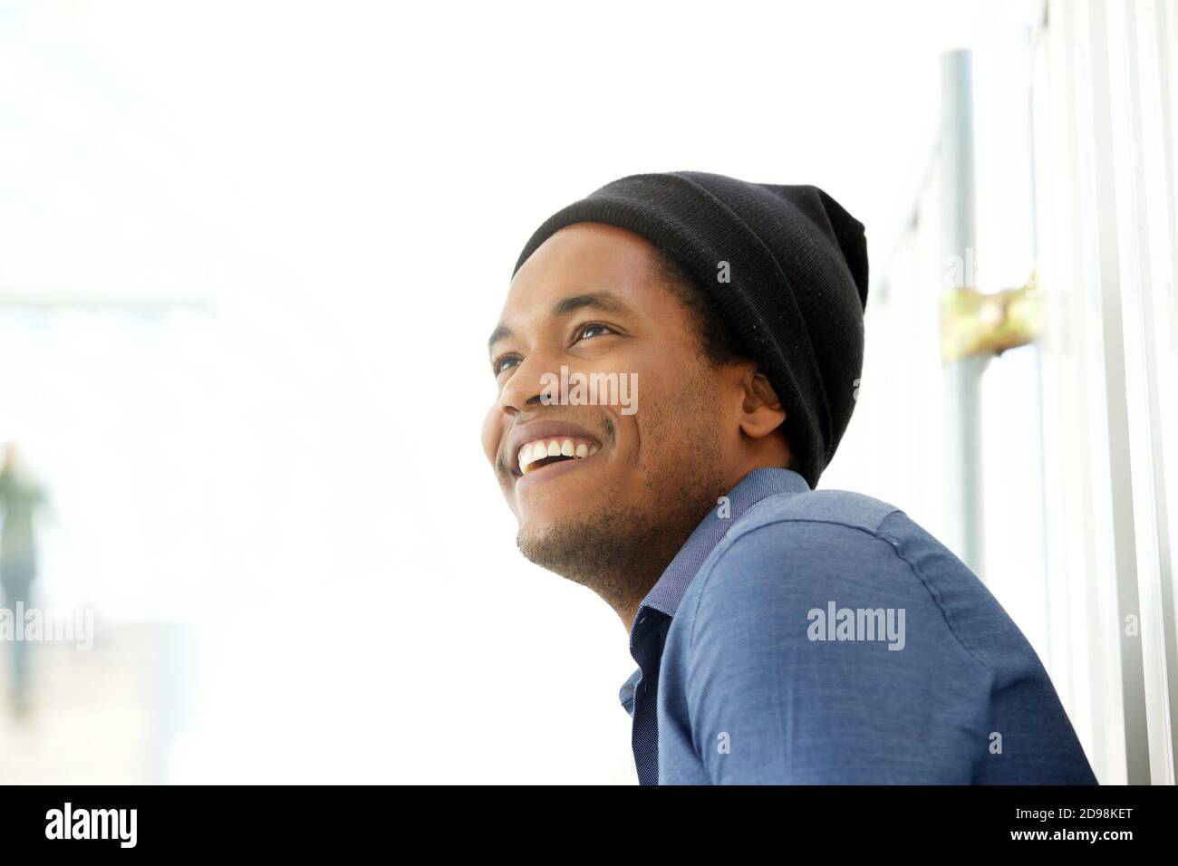 Close up side portrait of handsome young black man smiling and looking ...