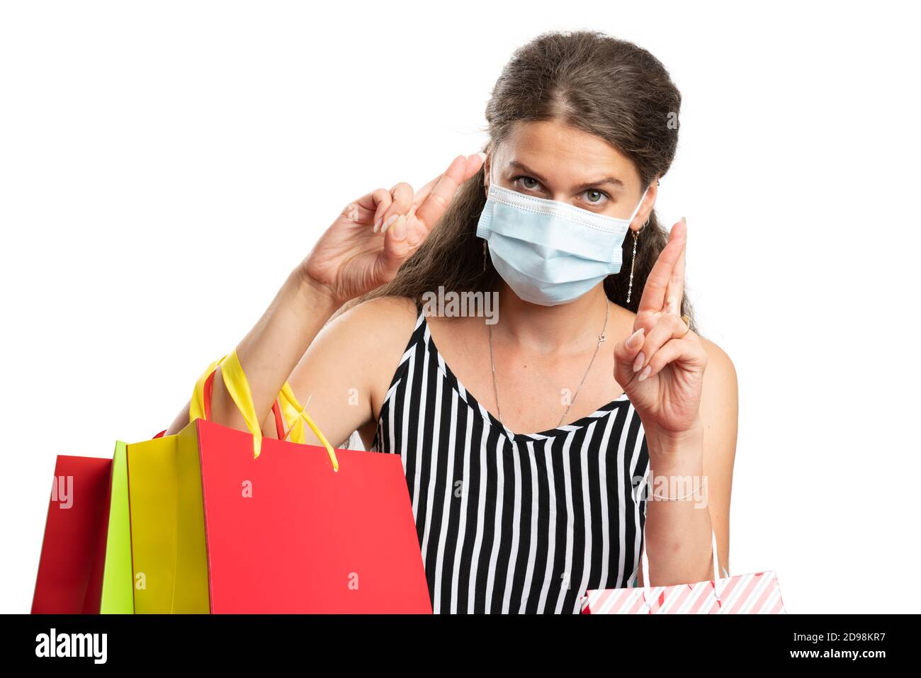 Female person wearing surgical or medical  to prevent covid19 sars virus influenza infection making double fingers crossed good luck gesture holding c Stock Photo