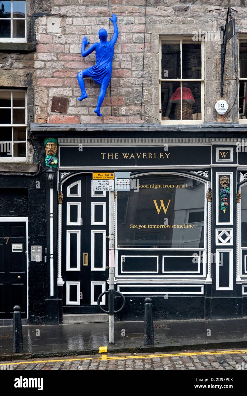 Figure of a 'blue man' climbs the wall of The Waverley bar in St Mary's Street, Edinburgh - at a time when all pubs are closed due to covid-19. Stock Photo