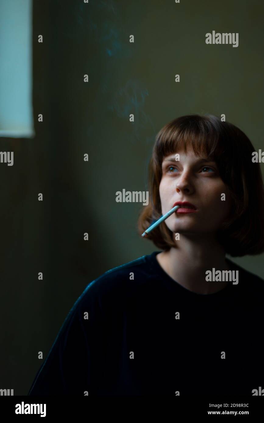 Portrait of a young beautiful girl of generation Z smoking a cigarette