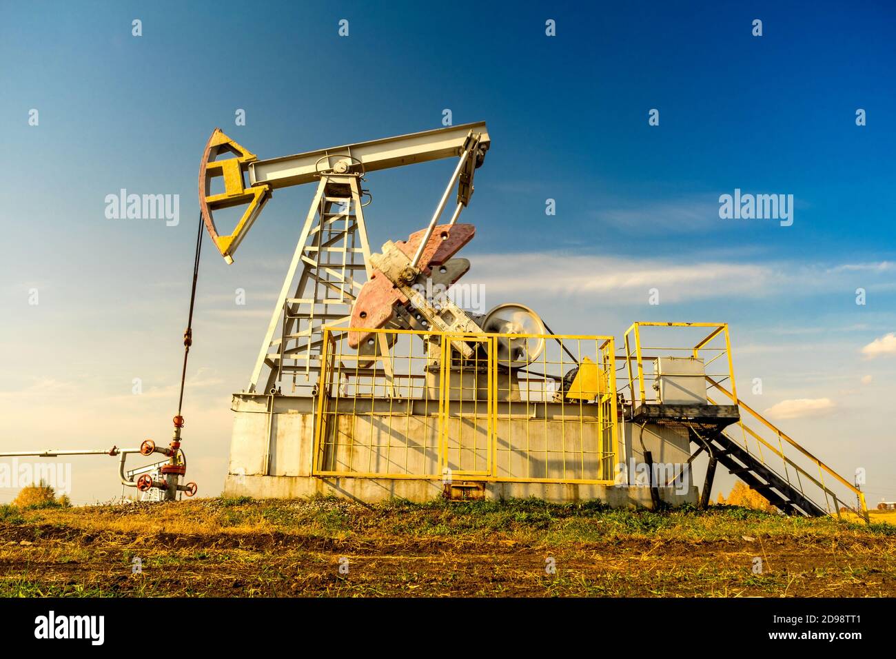 Oil rigs-rocking on the oil field near the road. Oil rig. Oil industry equipment. Stock Photo