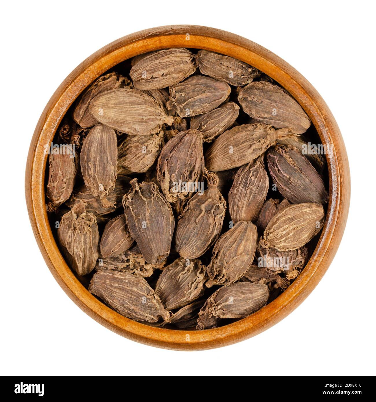 Black cardamom pods in a wooden bowl. Processed, dry fruits and seeds of Amomum subulatum, a spice with strong camphor-like flavour. Stock Photo