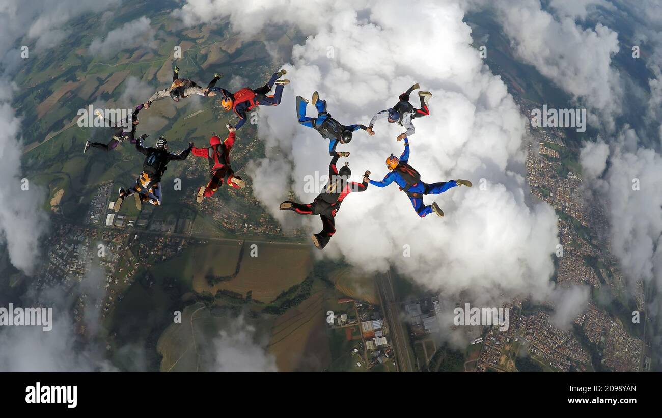Skydiving friends holding hands Stock Photo