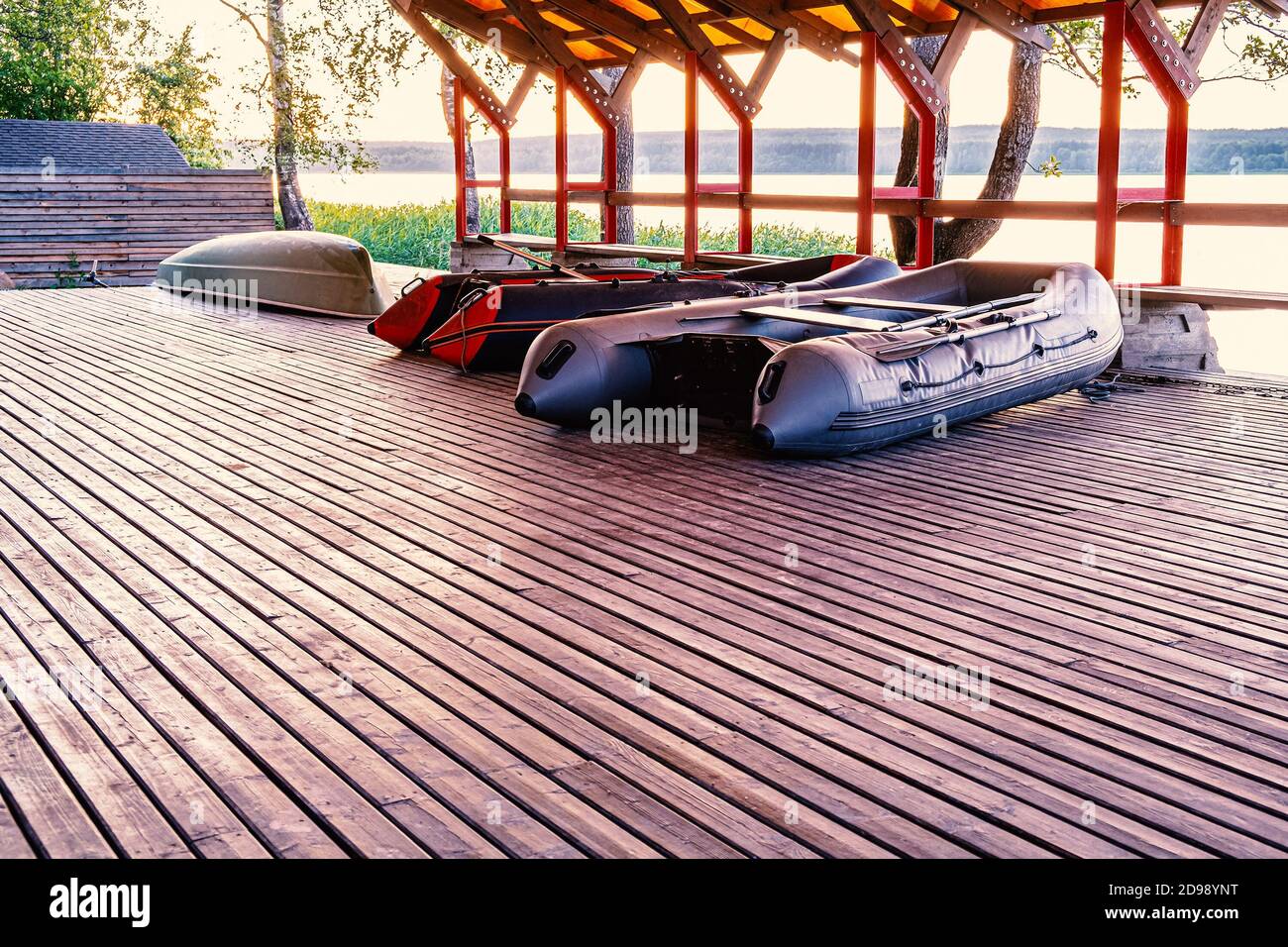 Under the roof are two inflatable fishing boats and one plastic pleasure boat. Boat drying shed