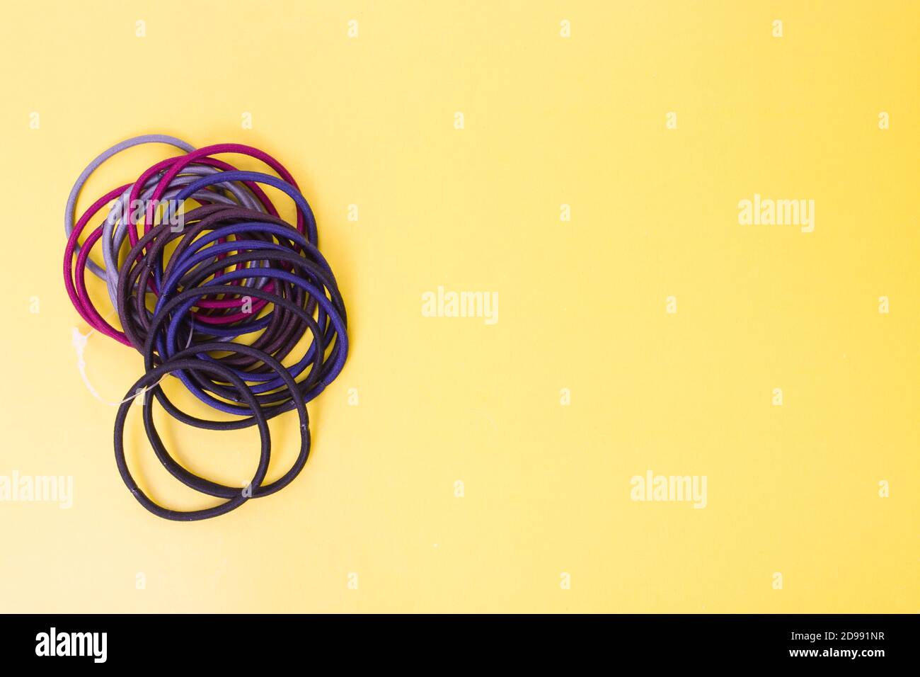 Pile of hair ties on yellow background Stock Photo