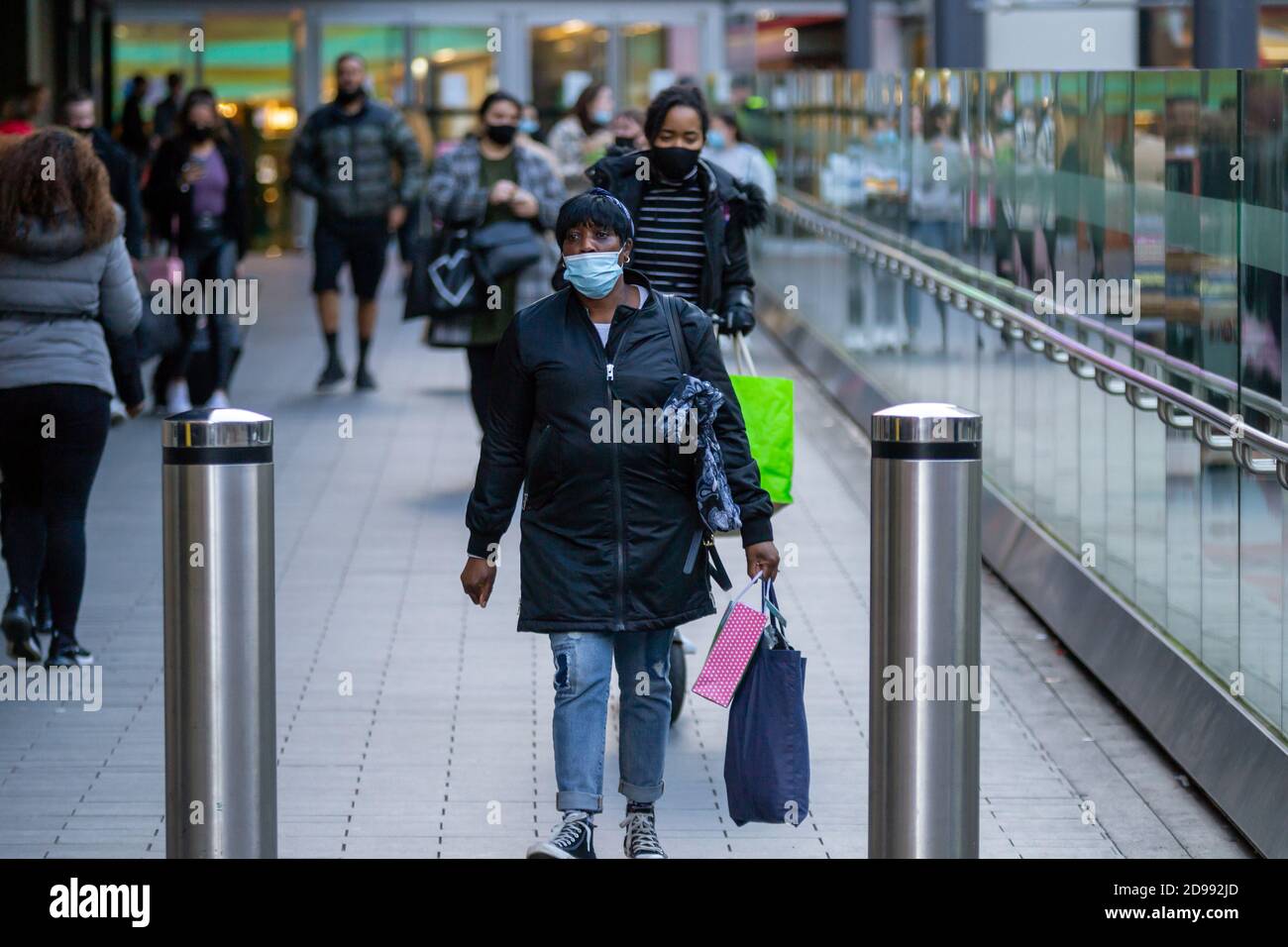 A woman carries her shopping down the ramp at Birmingham's Grand Central railway station on New Street. Birmingham, UK. Stock Photo
