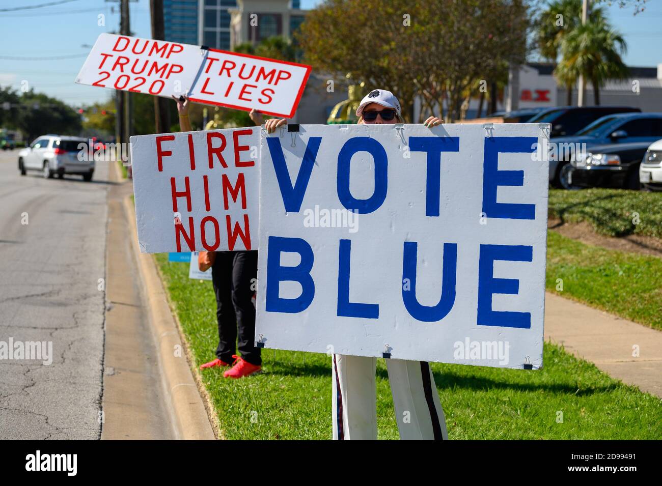 Houston, Texas, USA. 3rd Nov, 2020. Volunteers hold signs VOTE BLUE, DUMP TRUMP, TRUMP LIES outside a polling station in Harris County, Houston, Texas, USA. Credit: Michelmond/Alamy Live News. Stock Photo