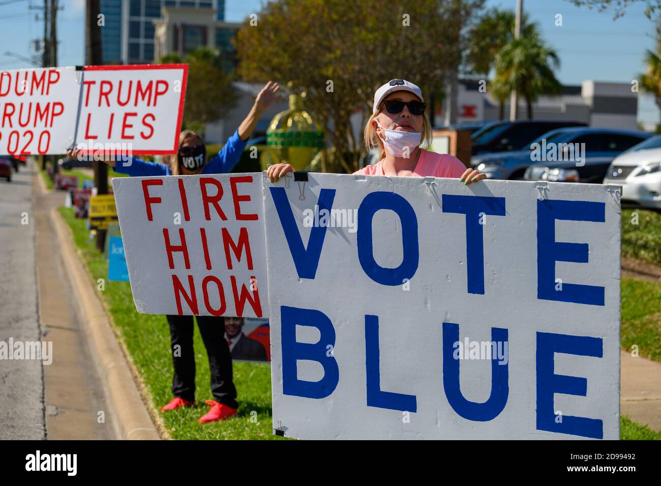 Houston, Texas, USA. 3rd Nov, 2020. Volunteers hold signs VOTE BLUE, DUMP TRUMP, TRUMP LIES outside a polling station in Harris County, Houston, Texas, USA. Credit: Michelmond/Alamy Live News. Stock Photo