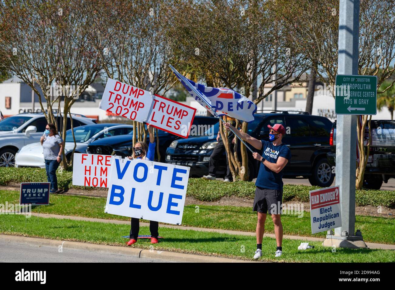 Houston, Texas, USA. 3rd Nov, 2020. A volunteer holds signs VOTE BLUE, DUMP TRUMP, TRUMP LIES outside a polling station in Harris County, Houston, Texas, USA. Credit: Michelmond/Alamy Live News. Stock Photo