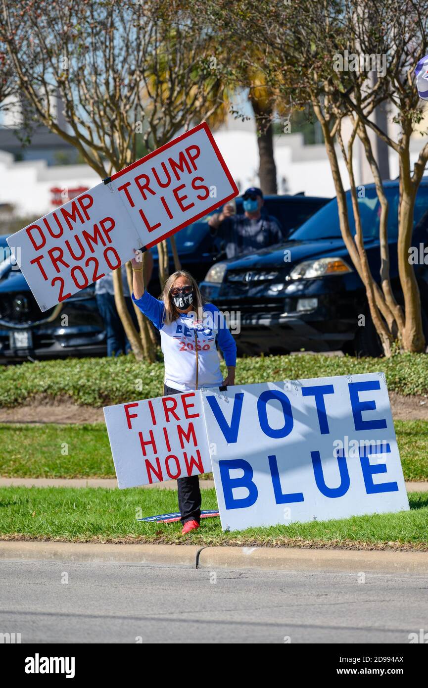 Houston, Texas, USA. 3rd Nov, 2020. A volunteer holds signs VOTE BLUE, DUMP TRUMP, TRUMP LIES outside a polling station in Harris County, Houston, Texas, USA. Credit: Michelmond/Alamy Live News. Stock Photo