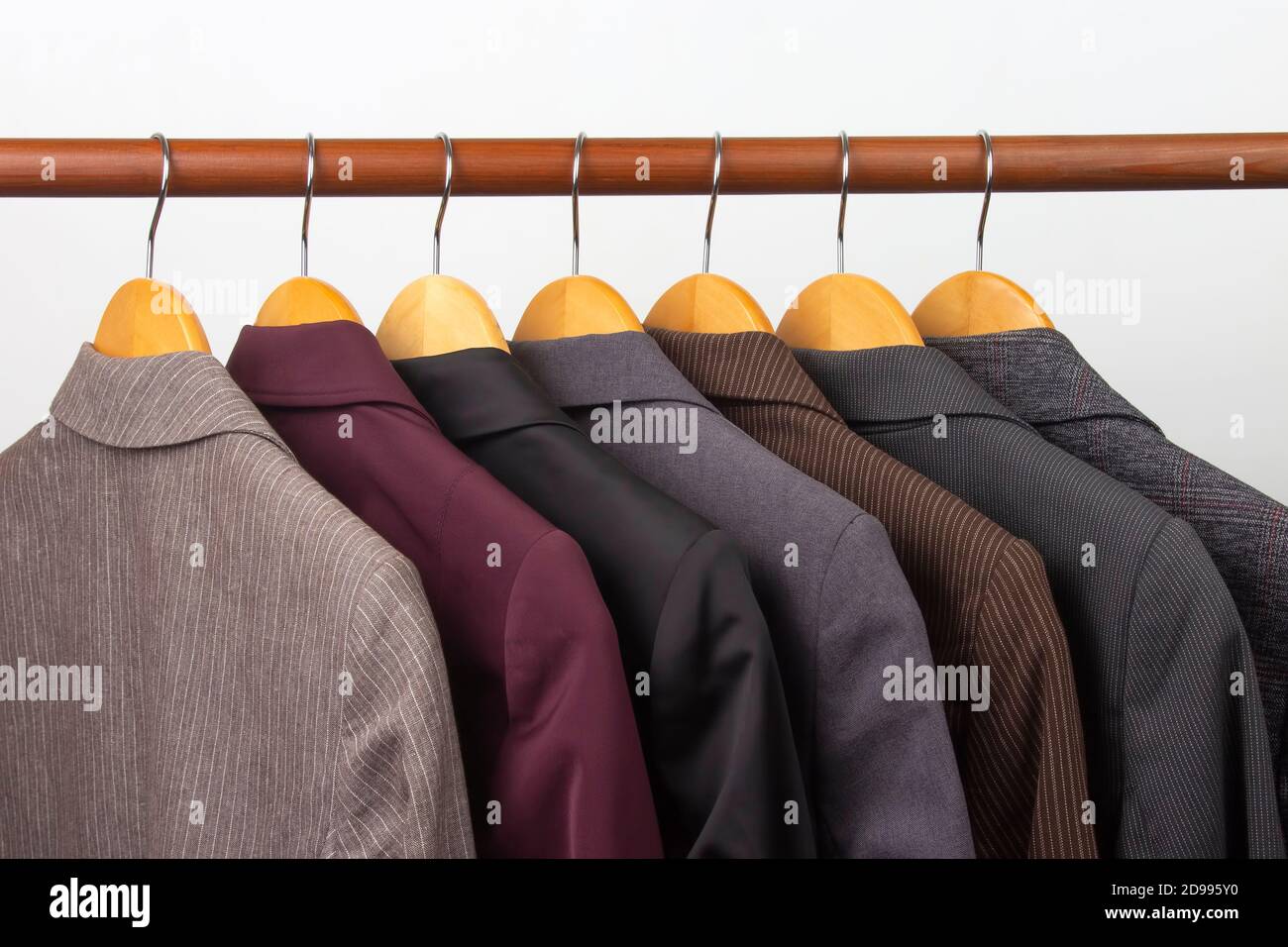 Different women's office classic jackets hang on a hanger for storing clothes. The choice of