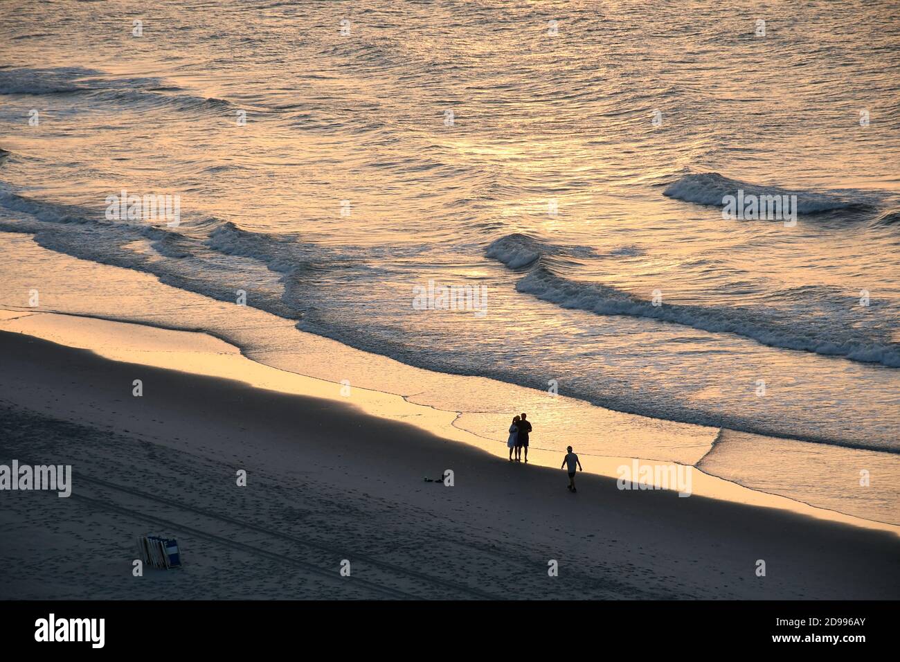 Silhouette of couple on beach watching morning sunrise Stock Photo - Alamy