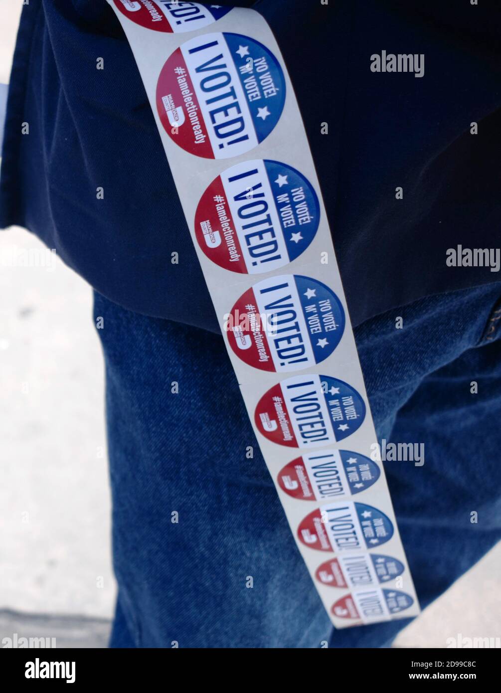 Miami, United States. 03rd Nov, 2020. I Voted stickers hang on the side of a poll worker on election day for the 2020 Presidential Election at the Miami Fire Station 2 in Miami, Florida on Tuesday, November 3, 2020. Lines at the polling sites are shorter than normal due to the amount of voters that early voted or used mail-in ballots. Social distancing is in effect because of COVID-19 pandemic. Photo by Gary I Rothstein/UPI Credit: UPI/Alamy Live News Stock Photo