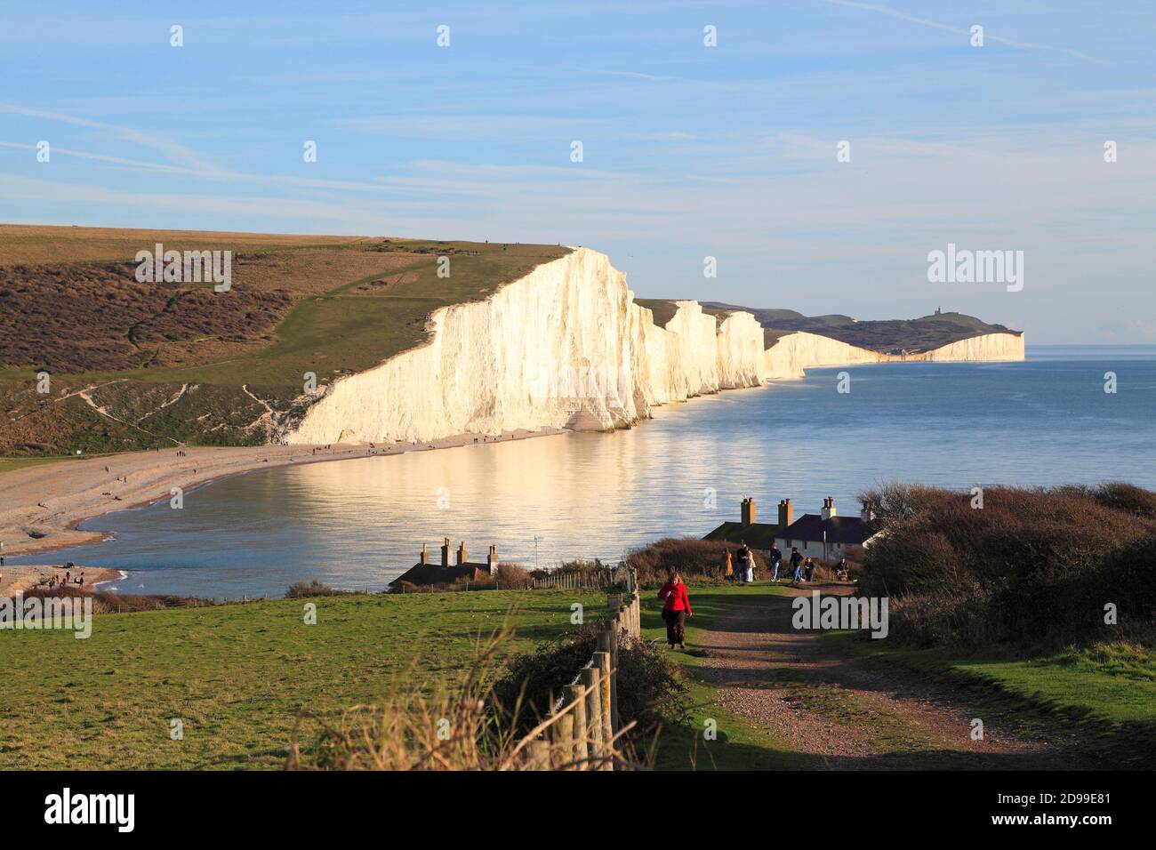 Walkers on the South Downs Way at Seaford Head, with Seven Sisters chalk cliffs coastline, East Sussex, UK Stock Photo