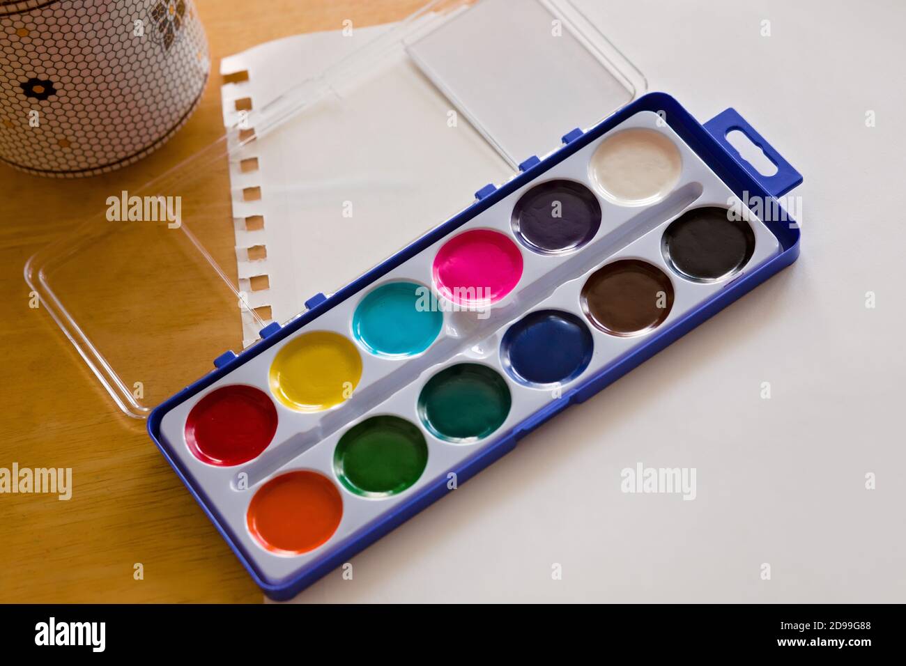 Watercolor Paint Set on White Paper on a Wooden Desk Stock Photo